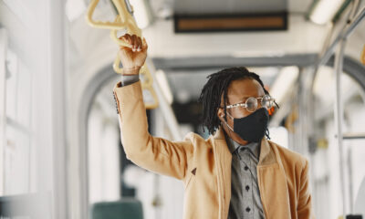 African american man riding city bus guy brown coat corona virus concept scaled e1788852645321.jpg